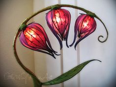 three red flowers are lit up in the shape of a circle with leaves on it