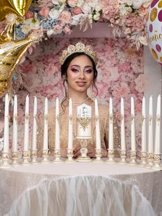 a woman standing in front of a table with candles