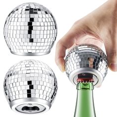 a hand holding a disco ball on top of a wine bottle with the lid open