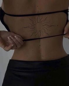 a woman's lower back with the sun drawn on her side and black string attached to it