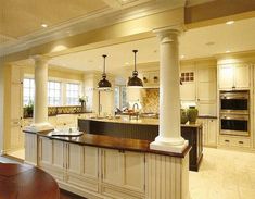 a large kitchen with an island in the middle and two ovens on each side