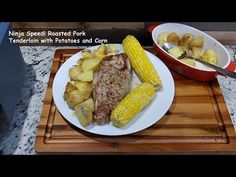 a white plate topped with meat and potatoes next to a bowl of corn on the cob