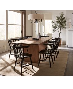 a dining room table surrounded by chairs and a chandelier