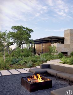 an outdoor fire pit in front of a modern house