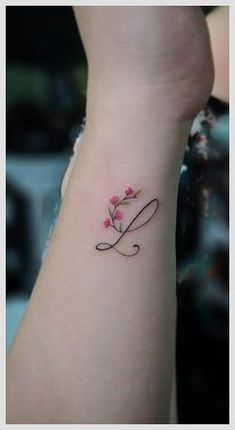 a woman's arm with a tattoo on it that has the letter l written in cursive writing