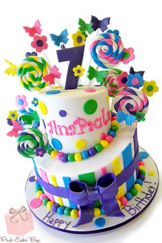 a birthday cake decorated with colorful candies and lollipops