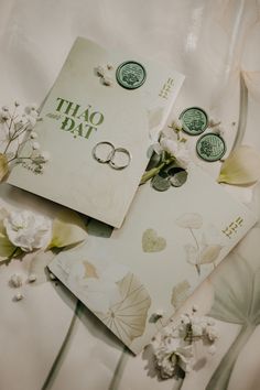 two wedding rings are laying on some cards