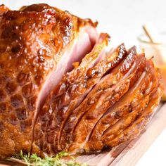 sliced ham sitting on top of a wooden cutting board