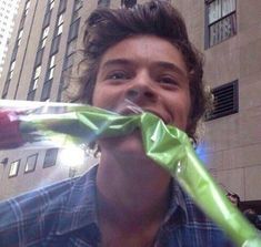 a man is holding a green ribbon in front of his face