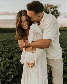 a man and woman hugging in a field