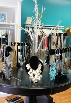 a table that has some necklaces and other jewelry on it in front of a blue wall