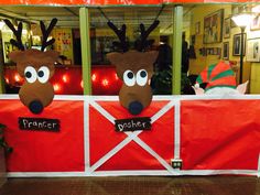 two fake reindeer heads on top of a red fence