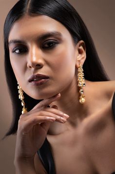 Elevate your elegance with our Kundan Earrings, showcasing beautifully crafted kundan motifs in a unique pattern, accentuated with a pearl drop for a contemporary touch. Crafted with precision, these earrings make a stunning statement for any occasion Finish: 22KT Gold Plating Material: Silver, Copper Alloy, Kundan Color: Gold Size: One Size Closure Type: Push Back Box Contains: 1 Pair of Earrings Elegant Pearl Earrings For Reception, Pearl Drop Earrings For Reception, Elegant Kundan Chandelier Earrings With Pearl Drop, Elegant Pearl Drop Danglers For Reception, Elegant Kundan Pearl Drop Earrings, Kundan Bridal Earrings With Pearl Drop For Formal Occasions, Elegant Kundan Danglers For Celebration, Formal Kundan Bridal Earrings With Pearl Drop, Elegant Pearl Meenakari Earrings For Diwali