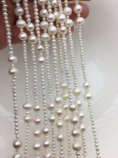 white pearls are being held by a hand