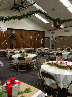 a banquet room decorated for christmas with presents on the tables