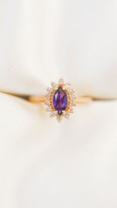 * Ring Material: Amethyst, Diamond, 14K Yellow Gold  * Ring Dimensions: 0.5x0.25Inch, 2 MM Edged Band * Size: 5.75 * Stone Weight & sizes: Amethyst - 0.48ct, Diamond - 0.15ct, J,K Color, SI2, I1 Clarity * Overall weight: 3g Amethyst Marquise Ring, Purple Diamond Ring In 14k Gold, Purple Gemstone Diamond Ring In 14k Gold, 14k Yellow Gold Amethyst Ring With Halo Setting, Luxury Amethyst Promise Ring With Halo Setting, Luxury Amethyst Halo Setting Promise Ring, Luxury Amethyst Ring With Halo Setting For Promise, Luxury Amethyst Rings With Halo Setting, Fine Jewelry Yellow Gold Amethyst Ring With Halo Setting