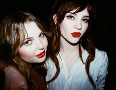 two beautiful young women with red lipstick on their lips