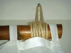 a piece of rope that is hanging from a wooden pole with white linen on it