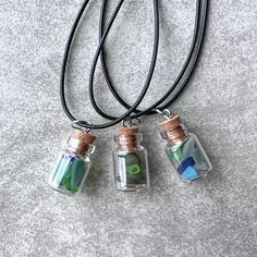 Genuine sea glass treasure bottle necklace!  Perfect gift for the junior beachcomber who is looking for treasures.  18" adjustable black leather cord, glass bottle with cork top - sealed (not for re-opening or cork will break, just for viewing and showing off the beautiful frosty colors).  The treasure bottles are hand filled with genuine sea glass, no piece I find is too small to show off.  Each bottle contains a variety of colors - a true one-of-a-kind piece of fashion jewelry. Treasure bottle measures approximately 1.5" in length. Not recommended for bathing or swimming.  Not recommended for children under 8. My jewelry is inspired by organic design, the beach and the ocean. Owning genuine sea glass jewelry is unique because each piece is one-of-a-kind. Jewelry is packaged for gifting a Glass Bottles With Corks, Bottle Necklace, Beach Combing, Organic Design, Sea Glass Jewelry, Glass Jewelry, Glass Bottle, Leather Cord, Sea Glass