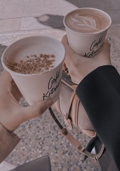 two people holding cups of coffee in their hands