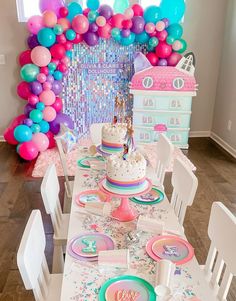 a table set up for a birthday party with balloons and confetti on it