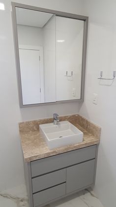 a bathroom sink with a mirror above it and a cabinet under the counter in front of it