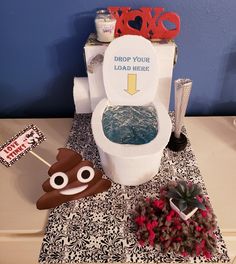 a toilet with decorations on top of it and a sign that says drop your load here