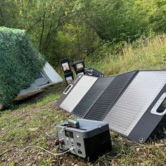 there is a solar panel laying on the ground next to some other things in the grass