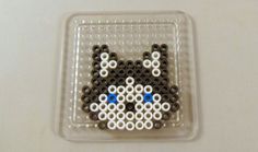 a small beaded animal is sitting in a plastic container