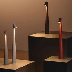 three different types of lamps sitting on pedestals