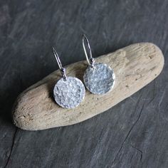 "Small Sterling Silver 1/2\" Hammered Disc Dangly Earrings These cute little sterling silver hammered round earrings would make a great gift for a friend who is hard to buy for. . . and they go with everything!  Here are the details about these cute dangly earrings:   * These simple sterling silver hammered round earrings are made with thick 1/2-inch discs that have been hammered for texture and polished to a bright finish, and are attached to handmade sterling silver ear wires. * Need a matching necklace?  https://www.etsy.com/listing/1546812806/ * Your earrings will be packaged in a sturdy box inside a bubble mailer and shipped via USPS First Class Mail. An upgrade to USPS Priority Mail is available for an additional fee. As with all of my items, everything is handcrafted by me in my jew Corvallis Oregon, Gemstone Stacking Ring, Disc Earrings, Dangly Earrings, Modern Earrings, Matching Necklaces, Round Earrings, Handmade Sterling Silver, Sterling Earrings