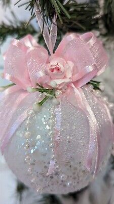 a pink ornament hanging from a christmas tree with sequins on it