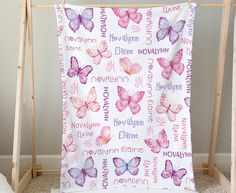 a pink and purple butterfly blanket hanging on a clothes rack