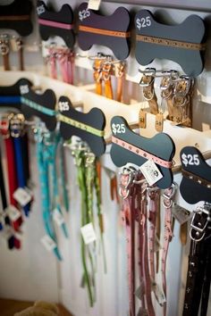 there are many key holders on the wall with ribbons attached to them and hanging from hooks