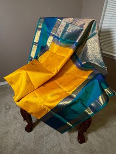 Traditional mango yellow and teal double border (rettai pettu) kanchipuram pure silk saree. With peacock and Rudraksh motifs woven alternating all over the body.The border has graceful peacock motifs which runs along the pallu with paisley motif intricately woven to give a complete rich look. Comes with falls, pico and tassels. Blouse details: Front hook with back strings chest size: 38 inches with 3 inch margin waist size: 32 inches with 3 inch margin sleeve length: 11 inch Front length:15 inch Tassels Blouse, Peacock Motifs, Mango Yellow, Garland Wedding Decor, Blue Silk Saree, Yellow And Teal, Paisley Motif, Blouse Details, Wedding Saree Collection