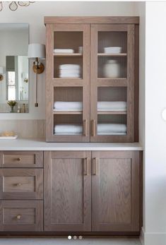 a bathroom with wooden cabinets and white counter tops