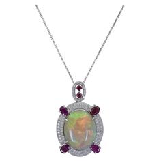 A beautiful and rare pendant necklace showcasing an oval cabochon opal, set in a diamond encrusted mounting accented with vibrant rubies. Suspended on a thin 18k white gold chain. Opal weighs 39.14 carats. Rubies weigh 4.05 carats total. Diamonds weigh 1.00 carats total. 2.00 inch (L) x 1.25 inch (W) Ruby Diamond Pendant, Turtle Jewelry, Turtle Pendant, Ruby Diamond, Fancy Color Diamonds, Diamond Pendant Necklace, Diamond Pendant, Colored Diamonds, Jewelry Necklace Pendant