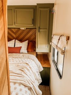 a small bedroom with a bed and wooden headboard on the wall next to a window