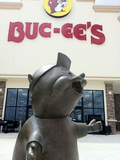 a large metal pig statue in front of a buc - ee's store