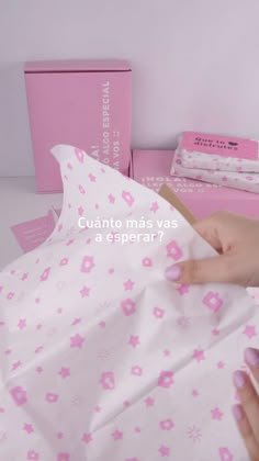 a woman is wrapping paper with pink flowers on it and the words, cuanto mas vas a esperar?