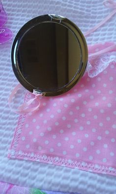 a mirror sitting on top of a pink cloth