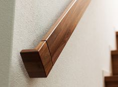 a wooden door handle on the side of a wall next to some stairs and steps