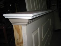 the top of a white cabinet with wood paneling on it's sides and bottom