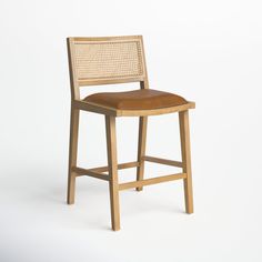 a wooden stool with a leather seat on a white background in front of a wall