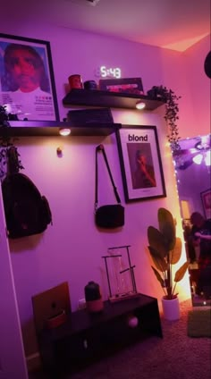 a living room with purple lighting and pictures on the wall, plants and other decorations