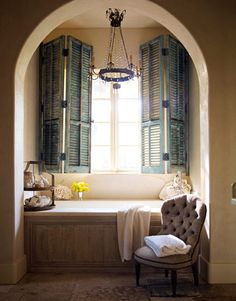 a bath room with a tub and a chair