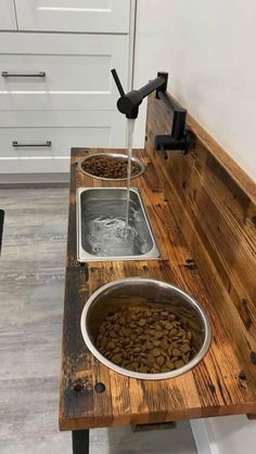 a wooden bench with two bowls filled with dog food on it and water running from the faucet