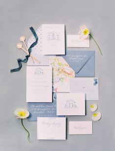 the wedding stationery is laid out on top of each other with flowers and ribbons