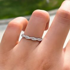 a woman's hand with a wedding band on it, and the ring is white gold