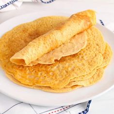 stack of pancakes on white plate with blue and red napkin